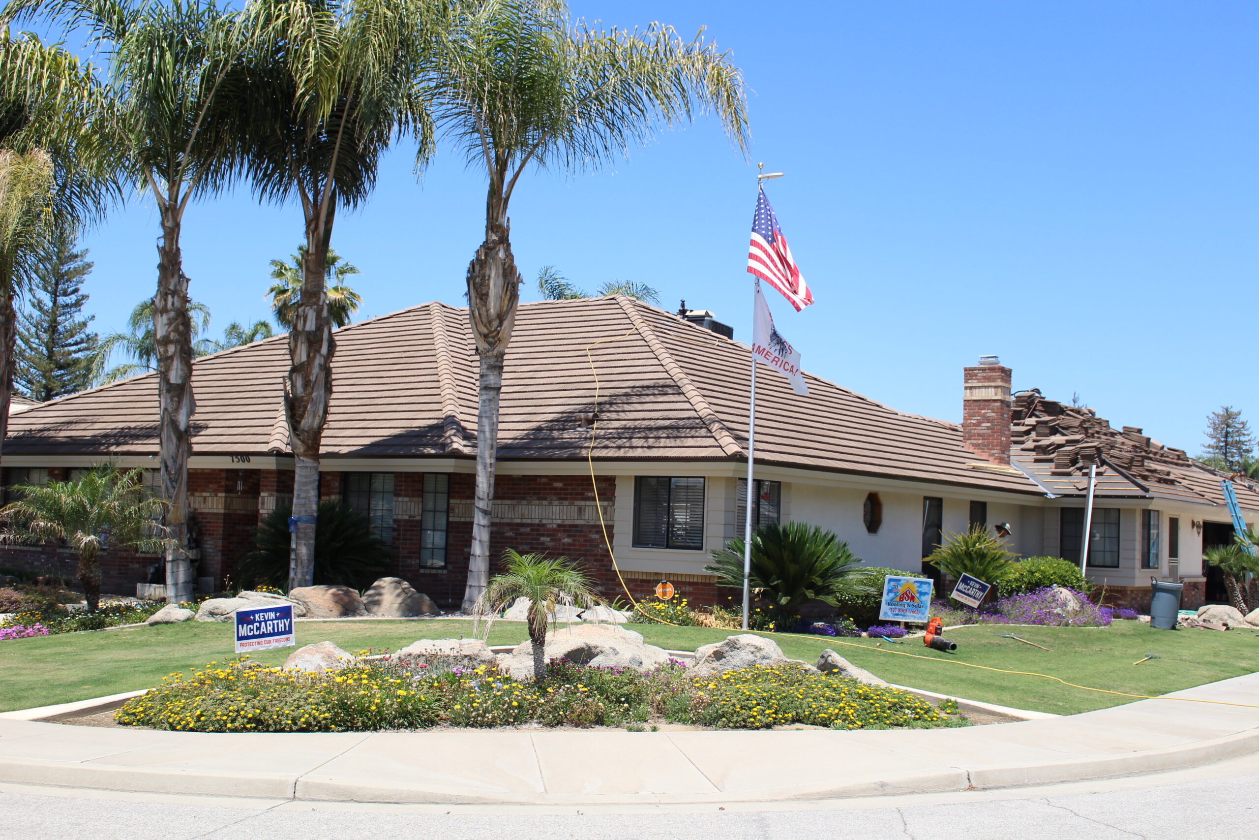Concrete tile staged on a Bakersfield roof mid re-lay