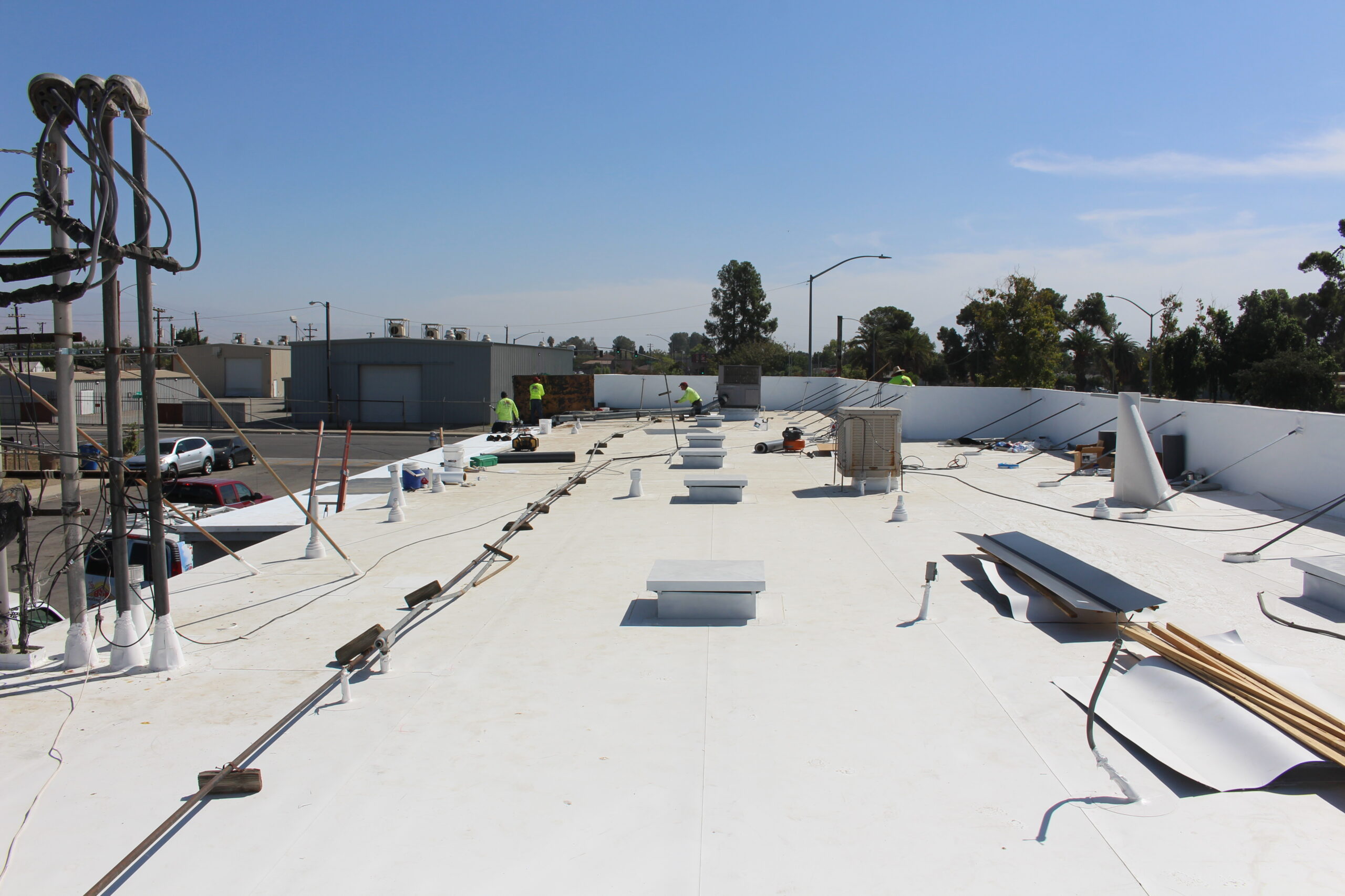 BSW crew finishing a white TPO membrane on a commercial roof
