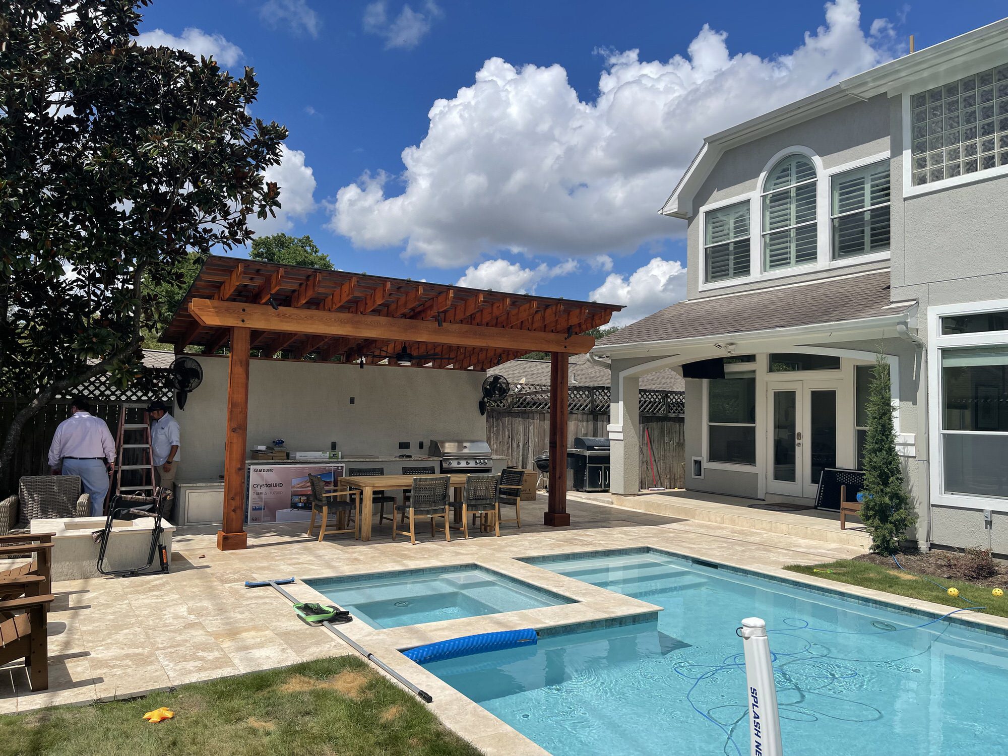 Pergola and outdoor kitchen beside a pool