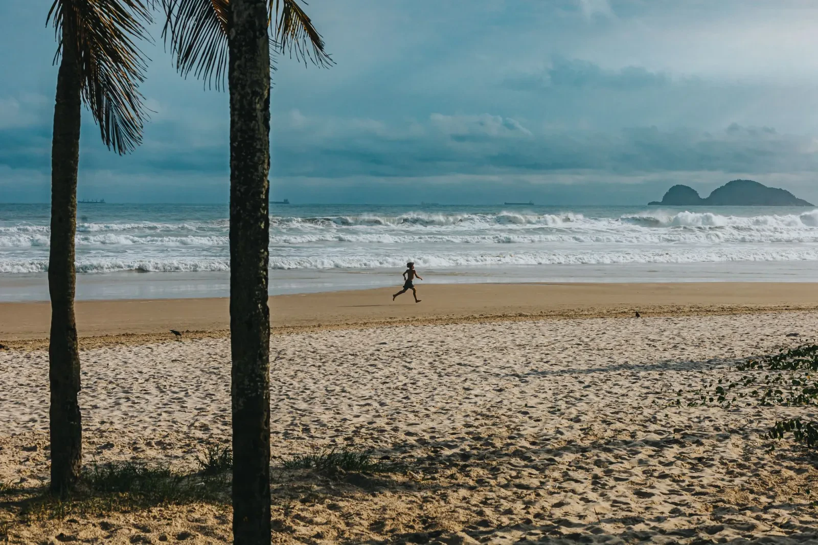 Runner on an empty beach at sunrise
