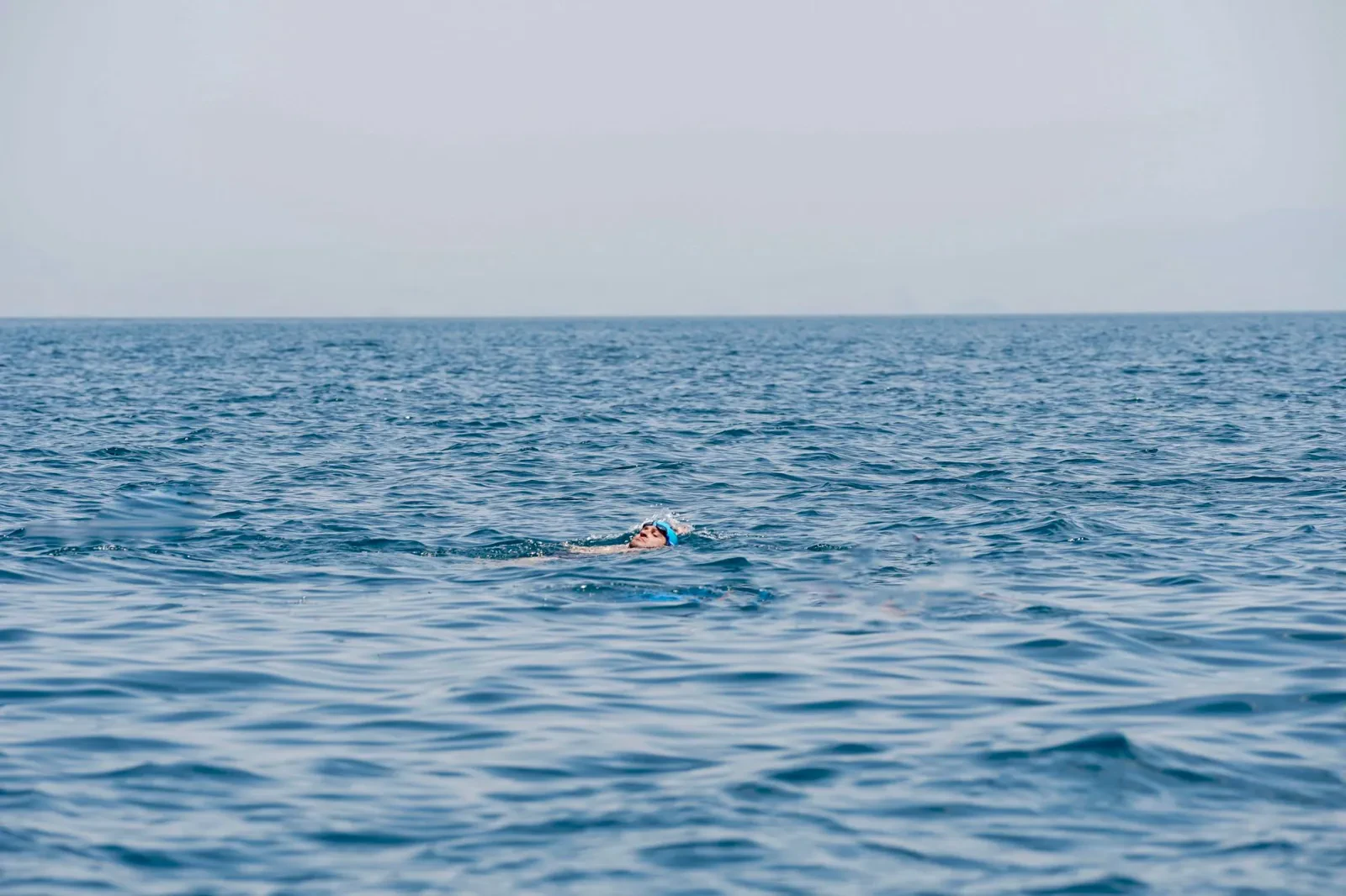Lone swimmer in a calm open ocean