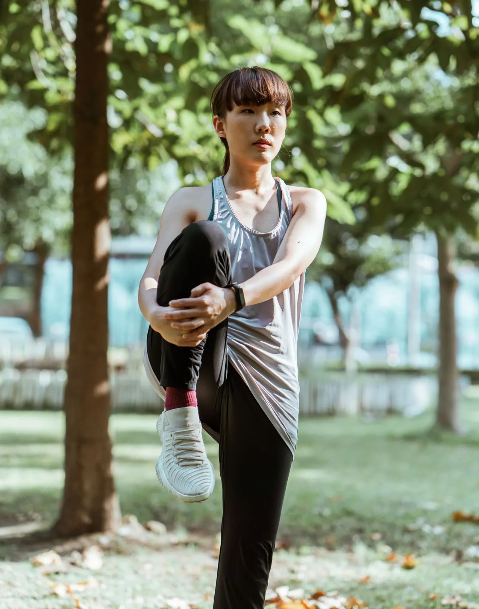 Runner stretching her legs in a sunny park